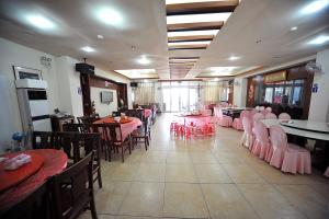 un ristorante con tavoli, sedie e tavoli rosa di Taijing Hotel a Beigan