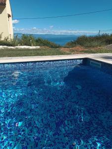a swimming pool with blue water in a house at Casa Andrea in Mošćenička Draga