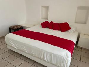 曼萨尼约Condominio Puerto Las Hadas的卧室里有一张大床，配有红色枕头 更多32张照片