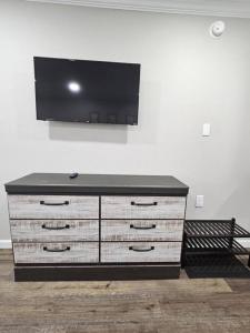 a dresser with a flat screen tv on a wall at The Sunshine Suite in Cleveland