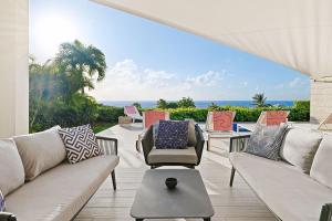 d'une terrasse avec des canapés et des chaises donnant sur l'océan. dans l'établissement Westmoreland Hills 11-Whitehaven villa, à Saint James