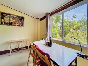 a room with a desk and a window and a table and chairs at Sunanta Bungalow in Ko Lanta +26 photos