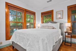 a bedroom with a large white bed with windows at LeMay Haus - Fire Pit, Heated Pool & Close to Main in Fredericksburg +55 photos