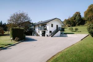 a driveway leading to a white house at Apartments Sole in Podčetrtek