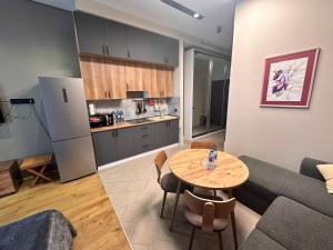 a kitchen and a living room with a table and a couch at Sea Breeze Light House 2 Studio Apartment in Baku