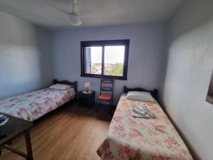 a small room with two beds and a window at Hotel Garibaldi in Piratini