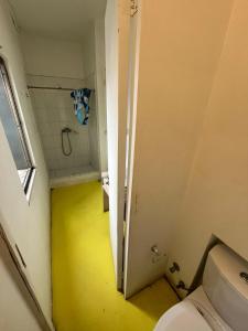 a bathroom with a toilet and a yellow floor at Hotel Nativo in Santiago