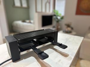 a black camera on a table in a living room at Le Cocon d'Alice - Cosy, calme, central et climatisé in Annecy