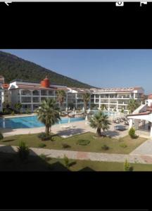 Un gran hotel con piscina y palmeras. en Akbük palace, en Akbük