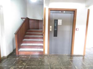 a hallway with a door and stairs in a building at Kitnet Canela Plaza Serrana in Canela