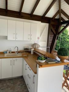 a kitchen with white cabinets and a wooden counter top at Le Jardin Zen in Bouillante