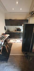 a kitchen with a table and a black refrigerator at διαμέρισμα Αλαμάνας 9 in Paphos