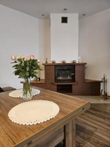 a living room with a table with a vase of flowers at Domek Zacisze Myśli in Elblag