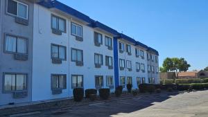 a white building with windows and bushes next to a street at MetroParc 'nSuites in Stockton