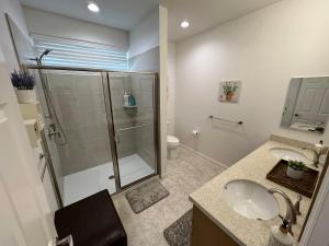 a bathroom with a glass shower and a sink at New Tropical Island Ohana near Beach with community Pool Spa Gym PingPong and more in Waianae +44 photos