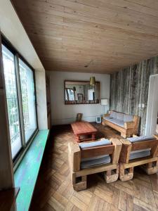 a living room with wooden ceilings and tables and windows at Hotel Nativo in Santiago
