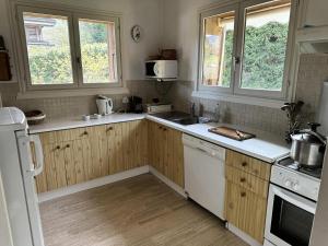 a kitchen with wooden cabinets and white appliances at Chalet Lombard - CHALET 10 PERSONNES MAE-2711 in Combloux
