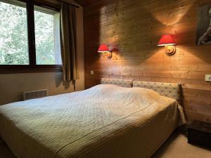 a bedroom with a bed and two lamps on the wall at Chalet Lombard - CHALET 10 PERSONNES MAE-2711 in Combloux +7 photos