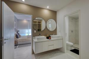 a bathroom with a sink and a toilet and a mirror at Lumina at Marea Cabo San Lucas in Cabo San Lucas +21 photos