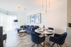 a living room with a blue couch and a table at Let's Sea by 2HomeRent in Gąski