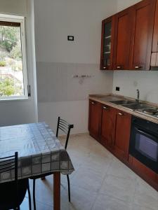 a kitchen with a table and a sink and a stove at Residence Conca D'oro in Copanello