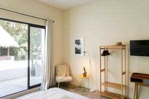 een slaapkamer met een bed en een glazen schuifdeur bij Casa Chayote Azul in Sayulita