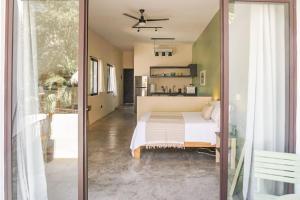 een slaapkamer met een bed en een glazen schuifdeur bij Casa Chayote Verde in Sayulita