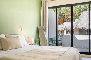 een slaapkamer met een bed en een groot raam bij Casa Chayote Verde in Sayulita