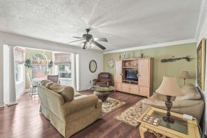 sala de estar con sofá, sillas y ventilador de techo en Domingos Beach Bungalow- The Coffee House, en Myrtle Beach