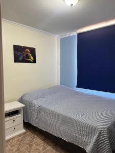 a bedroom with a bed and a blue wall at Dept Hermosa Vista, Las Condes in Santiago +6 photos