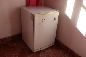 a white refrigerator in a corner of a room at Establecimiento turistico LAS AMARAS in Tumbaya