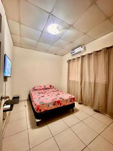 um quarto com uma cama e uma TV em Casa Doleguita em David