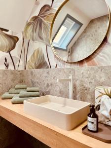 un bagno con un lavandino bianco e uno specchio di leaf a Kirchheim