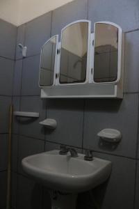a bathroom with two mirrors above a sink at Establecimiento turistico LAS AMARAS in Tumbaya +11 photos