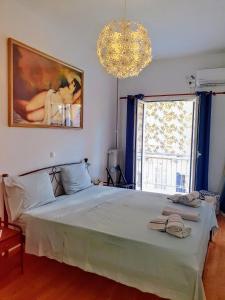 sypialnia z dużym łóżkiem i żyrandolem w obiekcie Success's Apartment w Atenach