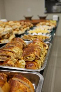 a row of trays filled with different types of pastries at Hotel Beirut in Aparecida +82 photos