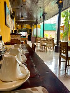 a row of white dishes on a table in a restaurant at Madroño Hostel in León