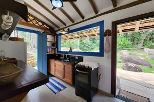eine Küche mit Spüle und Herd im Zimmer in der Unterkunft Bangalô com vista e piscina natural em Flechas in Ilhabela