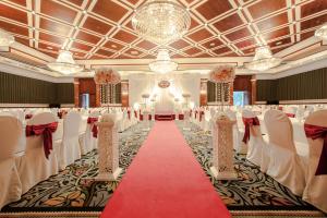 um salão de banquetes com mesas e cadeiras e um tapete vermelho em Army Hotel em Hanói