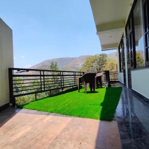 a balcony of a house with a green lawn at Hazelwood Kandaghat in Kandāghāt