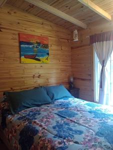 a bedroom with a bed with a wooden wall at Cabaña ALUMCO in Tigre