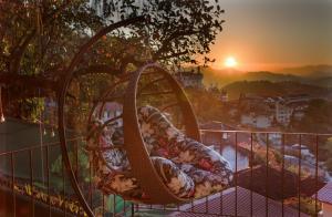 - un bébé sur une balançoire sur un balcon au coucher du soleil dans l'établissement Inn House Santa Teresa, à Rio de Janeiro