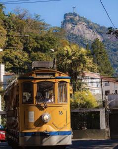 un chariot jaune conduisant dans une rue avec une montagne dans l'établissement Inn House Santa Teresa, à Rio de Janeiro