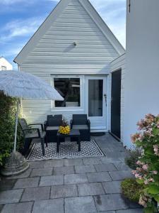 a patio with two chairs and a table and an umbrella at Garden house, Free parking in Zandvoort