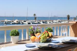 una mesa con un bol de fruta en un balcón con puerto en Sunset Mar Menor Puerto Bello, en La Manga del Mar Menor