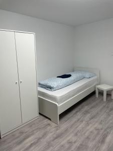 a white bedroom with a bed and a mirror at Ferien Wohnung Kassel Cassel Zentral in Kassel +1 photo
