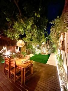 a table and chairs on a deck at night at Recanto de Ibiza in Pipa