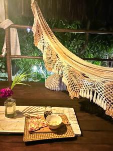 a table with a bowl of food and a hammock at Recanto de Ibiza in Pipa +26 photos