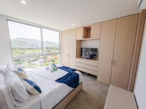 a bedroom with a bed and a large window at Salguero suite 714 in Gaira