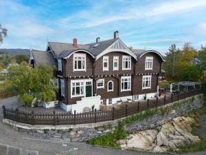 a large wooden house with a fence at Jervell Gjestehus rom 2 in Ålesund